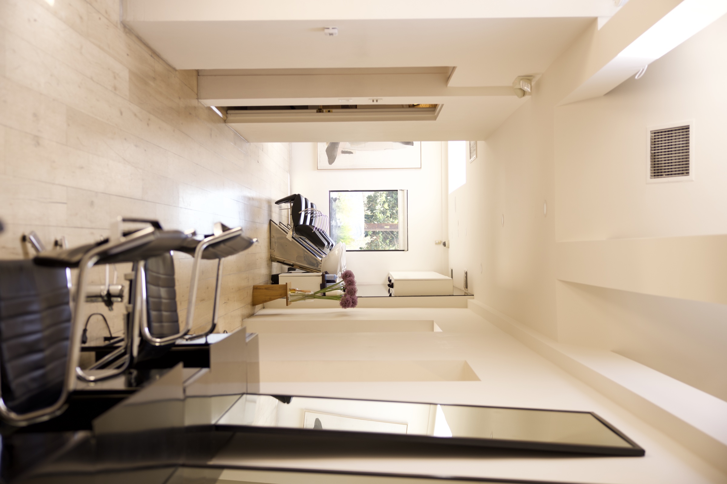 The OLLIN Beverly Hills corridor — daylight down the styling stations.